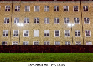 Windows Of A Yellow Brick School Building At Night Lit By Street Lamps.