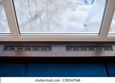 Windowsill, heating grid ventilation. Winter apartment heating. Modern double glazed windows