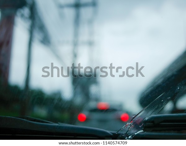 Windscreen wiper arm and blade removing rain\
from the windscreen