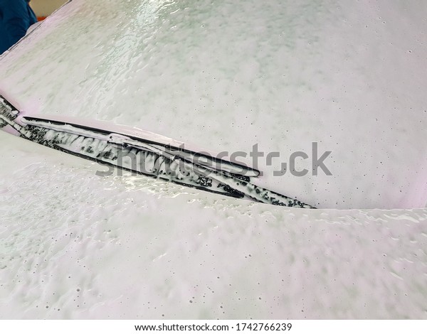 windscreen wiper\
blades coated with active washing foam for washing a dirty car,\
close up on car part,\
nobody.