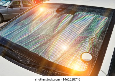 Windshield Of Car With Protective Reflective Sunscreen Surface Inside Car Parked On Street Hot Day With Sunbeams. Method For Protecting Heated By Sun Rays Inside Car