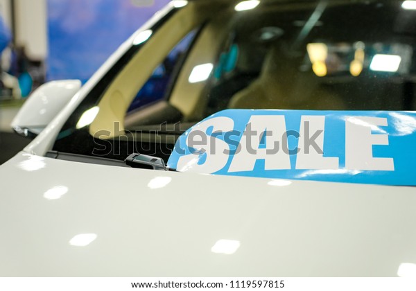 Windshield\
price sticker on a used white car for\
sale
