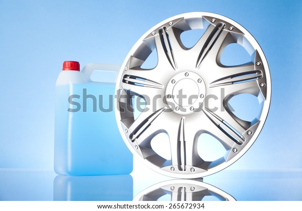 windshield washer fluid and alloy wheel on\
blue background