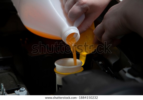 Windshield washer fluid being poured into the\
container in an\
automobile