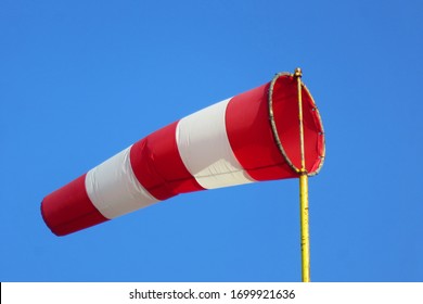 Windsock indicator of wind on runway airport.  Wind cone indicating wind direction and force. Horizontally flying windsock (wind vane) with blue sky in the background.                           
