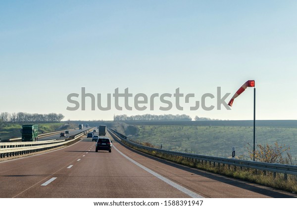 Windsock on the bridge of a\
motorway as an indication of the wind direction and the wind\
strength