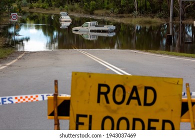 Windsor, Australia - March 25, 2021; A car and ute trapped on a flooded road  in Windsor.  The floodwaters camE well over the top of the vehicleS