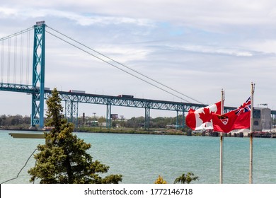 Windsor, Canada - May 21, 2020: Canada And Ontario Flags Seen Waving In-front Of The The US-Canada Border, Ambassador Bridge Crossing On Sunny Day. 