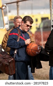 WINDSOR LOCKS, CT - APRIL 8: Geno Auriemma, Head Coach Of The UCONN Women's Basketball Champs, Autographs A Basketball For A Fan At A Homecoming Rally Held At Bradley Airport On April 8, 2009 In CT.