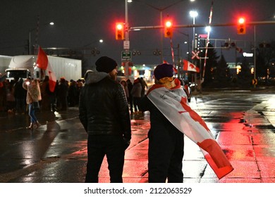 Windsor, ON - 2.11.2022: Two Young Protesters At The Trucker Convoy Blocking The Ambassador Bridge. Demonstration Against Vaccine Mandate In Ontario. Night Peaceful Protest