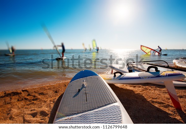 Windsurf boards on the sand at the beach.\
Windsurfing and active\
lifestyle