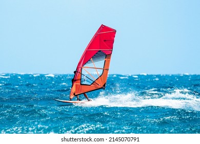 windsurfer have a fun riding the waves during a sunny summer day
				