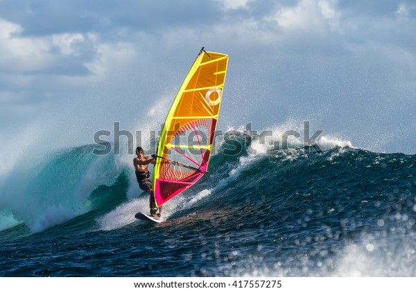 Windsurfer rides among the huge tubes\
and waves of the Indian Ocean on the island of\
Mauritius