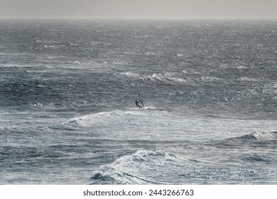 Windsurfer silhouette in rough waves.  - Powered by Shutterstock