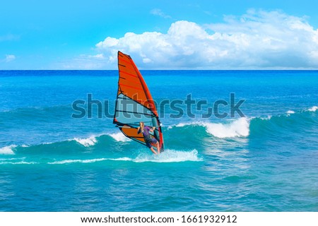 Windsurfer surfing the wind on waves in Alacati at beautiful cloudy sky - Cesme, Turkey 