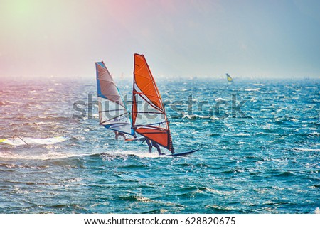 Windsurfer Surfing The Wind On Waves In Garda Lake, Recreational Water Sports, Extreme Sport Action. Recreational Sporting Activity. Healthy Active Lifestyle. Summer Fun Adventure. Hobby