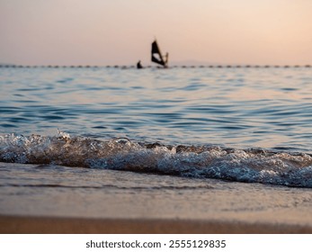 windsurfing against the background of sunset and waves - Powered by Shutterstock