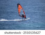 Windsurfing - like colorful butterflies against the blue sea in the bay on the island of Crete in Greece