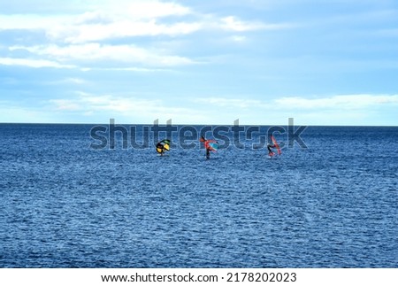Windsurfing sail boarding. Sailboarding sport. Surfer on board is surfing in sea. Surfer catches a wave on a surfboard. Sailing sports on board on waves in sea. Surfer on surfboard. 