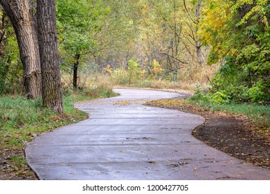 windy bike trail along the Poudre River in Fort Collins, Colorado - rainy day with fall colors