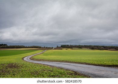 A Windy Rural Road Against A Dramatic Stormy Sky In Spring