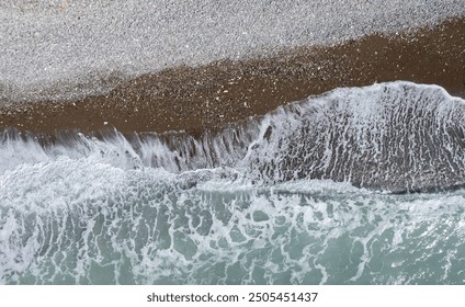 Windy waves crashing on a pebble beach. Drone aerial of stormy sea. Stormy waves view from above - Powered by Shutterstock