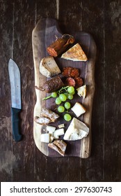 Wine Appetizers Set: Meat And Cheese Selection, Grapes And Bread On A Rustic Wooden Board Over A Dark Wood Background. Top View, Copy Space