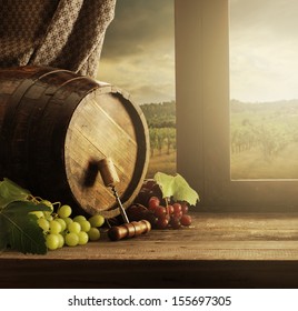 Wine barrel and grapes with vineyard on background