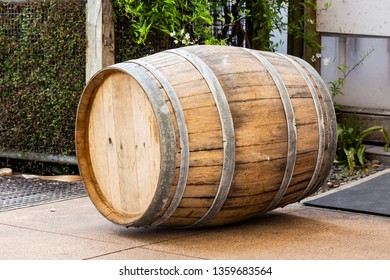 A Wine Barrel Lays On Its Side On A Tiled Floor.