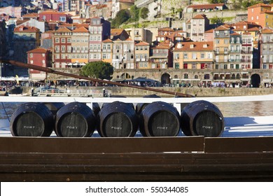 Wine barrels in Porto. Five barrels of Port wine on a boat. The town of Porto as a background. 