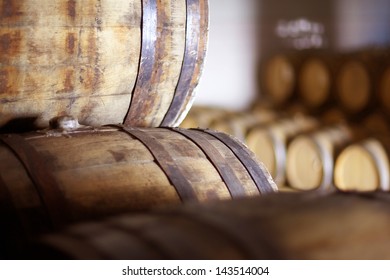 Wine barrels stacked in the old cellar of the winery.