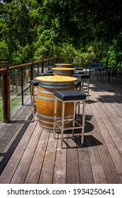 Wine barrels used as tables with stools on a deck for outdoor dining in the garden