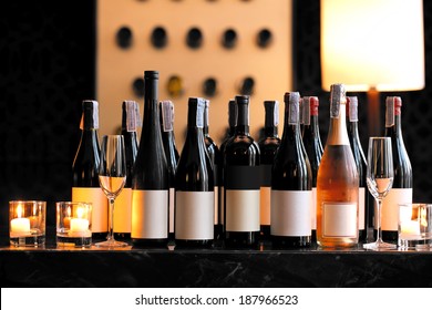 Wine Bottle With Candle And Empty Wine Glasses On Counter Bar