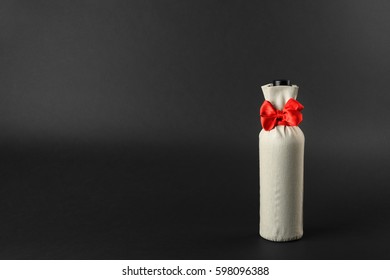 Wine Bottle In Gift Bag On Dark Background