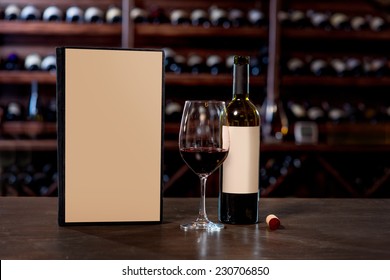 Wine Bottle With Glass And Menu On The Table At The Wine Cellar