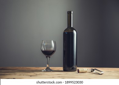 Wine Bottle And Glass With Opener On The Table