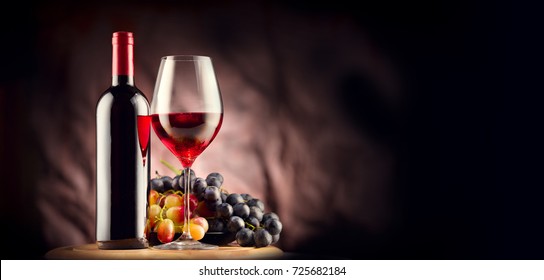 Wine. Bottle And Glass Of Red Wine With Ripe Grapes Still Life. Red Wine Over Black Background. Border Art Design.