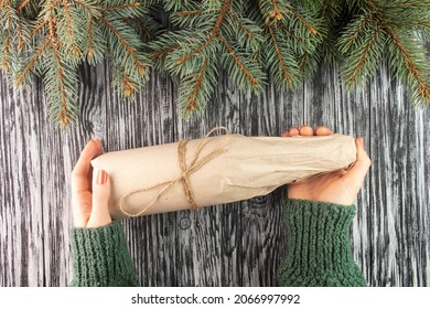 Wine Bottle Wrapped In Kraft Paper. Christmas Present. Woman Holding A Gift.