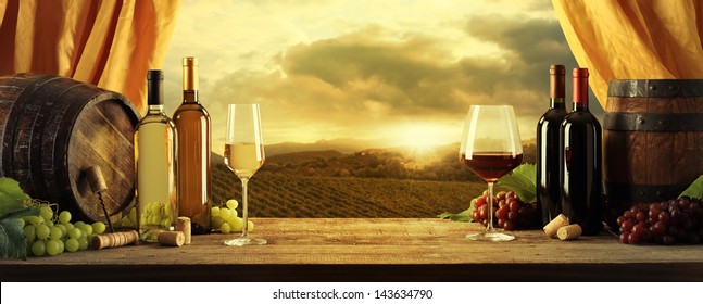 Wine Bottles, Barrels And Vineyard In Sunset