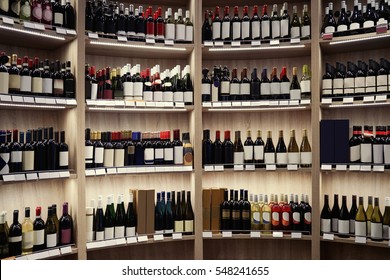 Wine Bottles On Wooden Shelves At Liquor Store