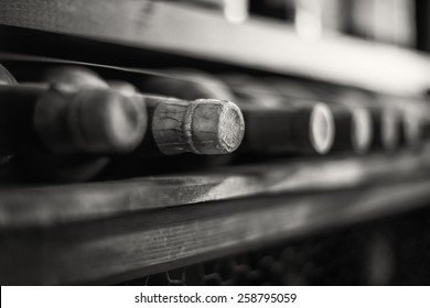 Wine Bottles Stacked On Wooden Racks. Black And White Photo.