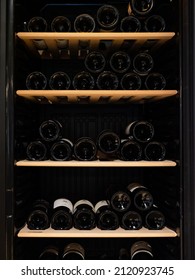 Wine bottles storing in refrigerator. Black background  - Shutterstock ID 2120923745