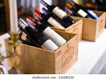 Wine Bottles In Wooden Boxes Are On The Table Restaurant. Wine Background.