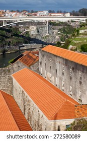 Wine cellars in Vila Nova de Gaia by the Douro river, city of Porto and Infante D. Henrique Bridge.