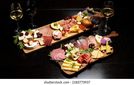 Wine and charcuterie and cheese board with a place for text. Prosciutto di Parma ham, blue cheese. Italian appetizers or antipasto set with gourmet food on table top view. Mixed delicatessen