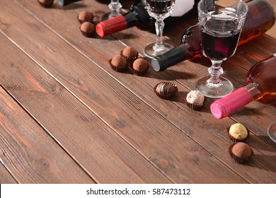 Wine and chocolates on wooden background