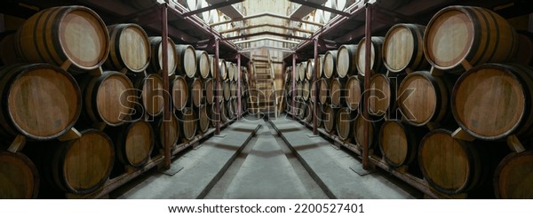 Wine or cognac\
barrels in the cellar of the winery, Wooden wine barrels in\
perspective. wine vaults. vintage oak barrels of craft beer or\
brandy. Wood stairs to the second\
floor