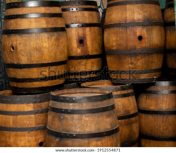 Wine and cognac oak barrels with metal\
hoops Stand on top of each other in several\
rows.