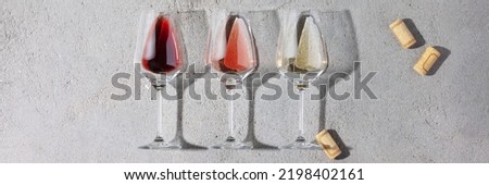 Wine composition with red, rose and white wine in glasses. Top view, flat lay. Wine bar, winery, wine degustation concept. Minimalistic trendy photography banner