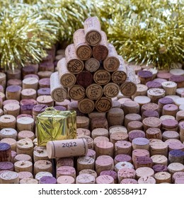 Wine Cork Christmas Tree With Marked Years In Front Of Golden Tinsel